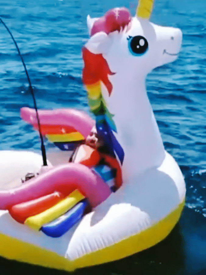 Man fishing for a shark on a unicorn float.