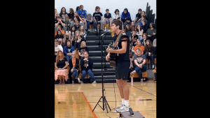 Logan Clough sings in High School gymnasium