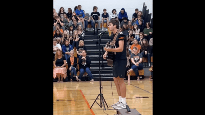 Logan Clough sings in High School gymnasium