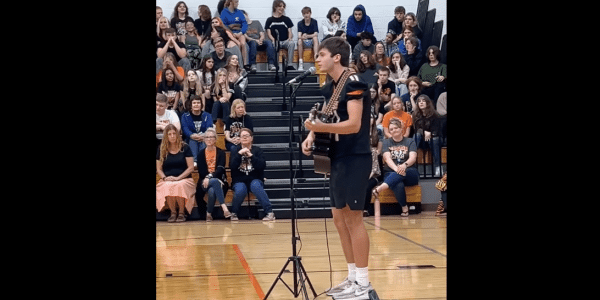 Logan Clough sings in High School gymnasium