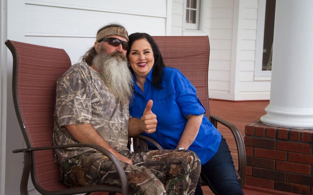Phil Robertson and Miss Kay pose together in chairs for picture.