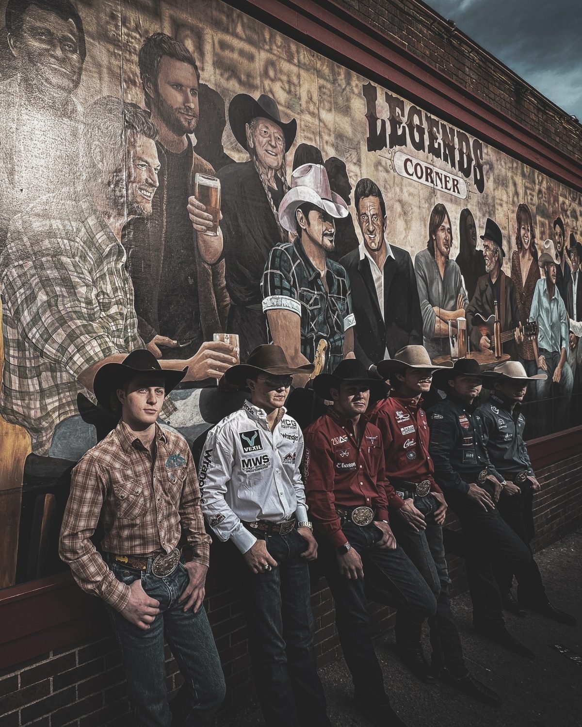 rodeo stars pose in front of Legends bar