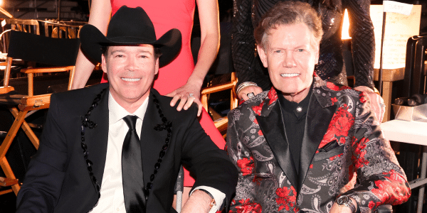 Clay Walker, who will play Randy Travis in a new biopic, sits with him at the 59th ACM Awards