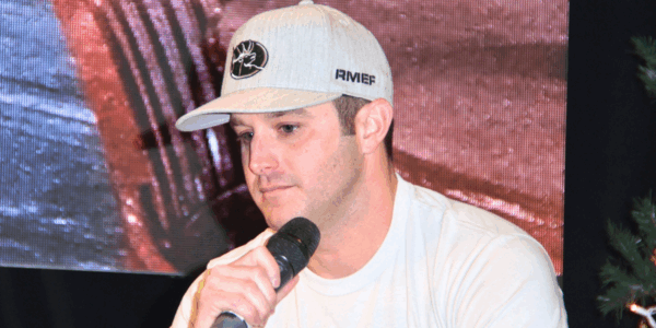 Easton Corbin holds a microphone and looks down...he just announced on August 28th that his stepdad passed away
