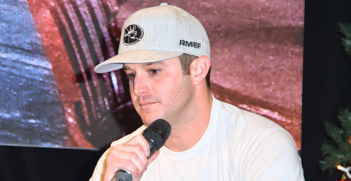 Easton Corbin holds a microphone and looks down...he just announced on August 28th that his stepdad passed away