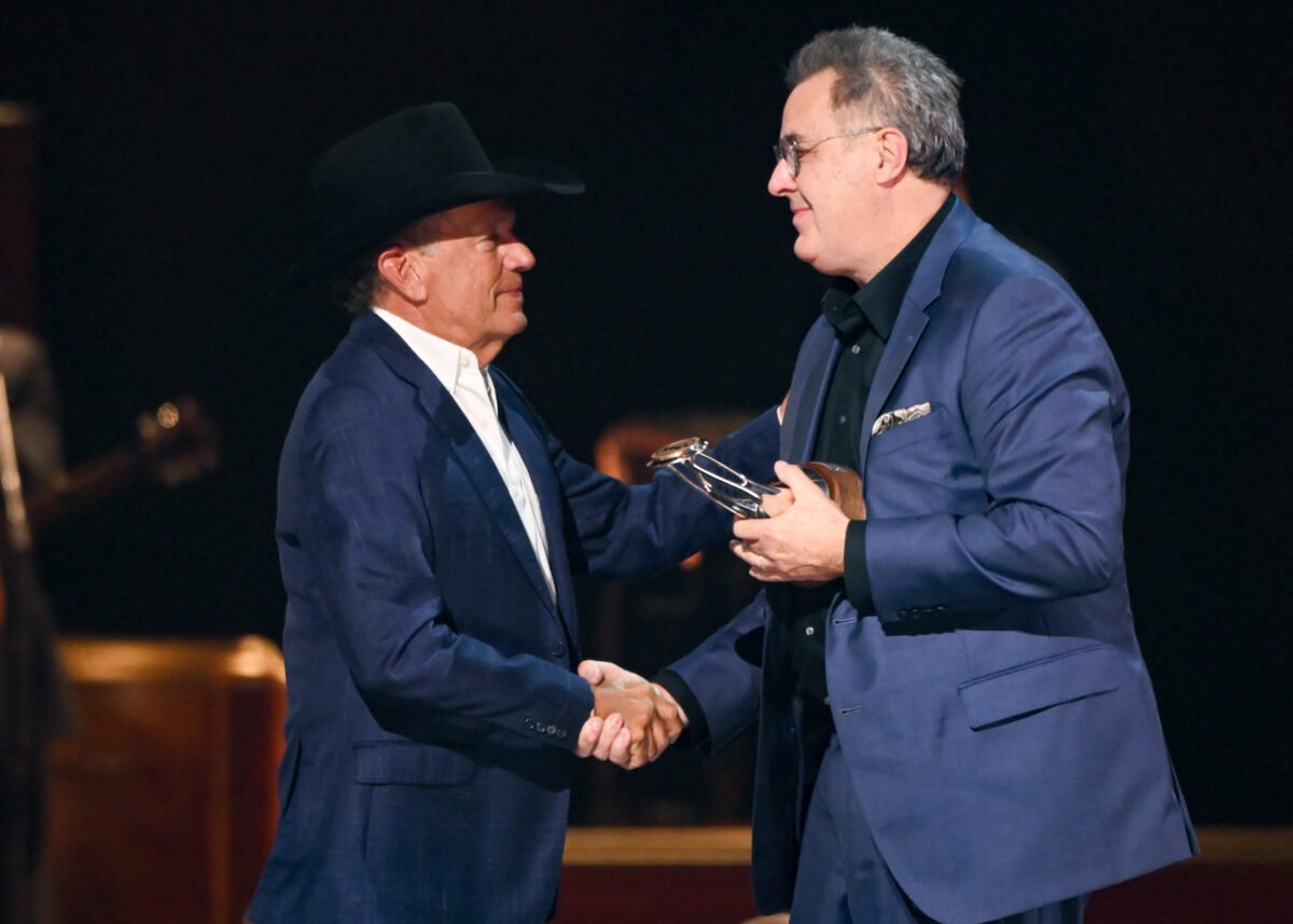 George Strait and Vince Gill shake hands onstage at the 2025 CMA Awards