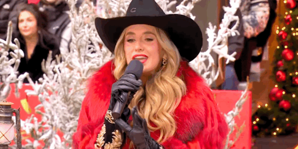 Lainey Wilson sings in a red jacket and black cowboy hat during the Macy's Thanksgiving Day Parade