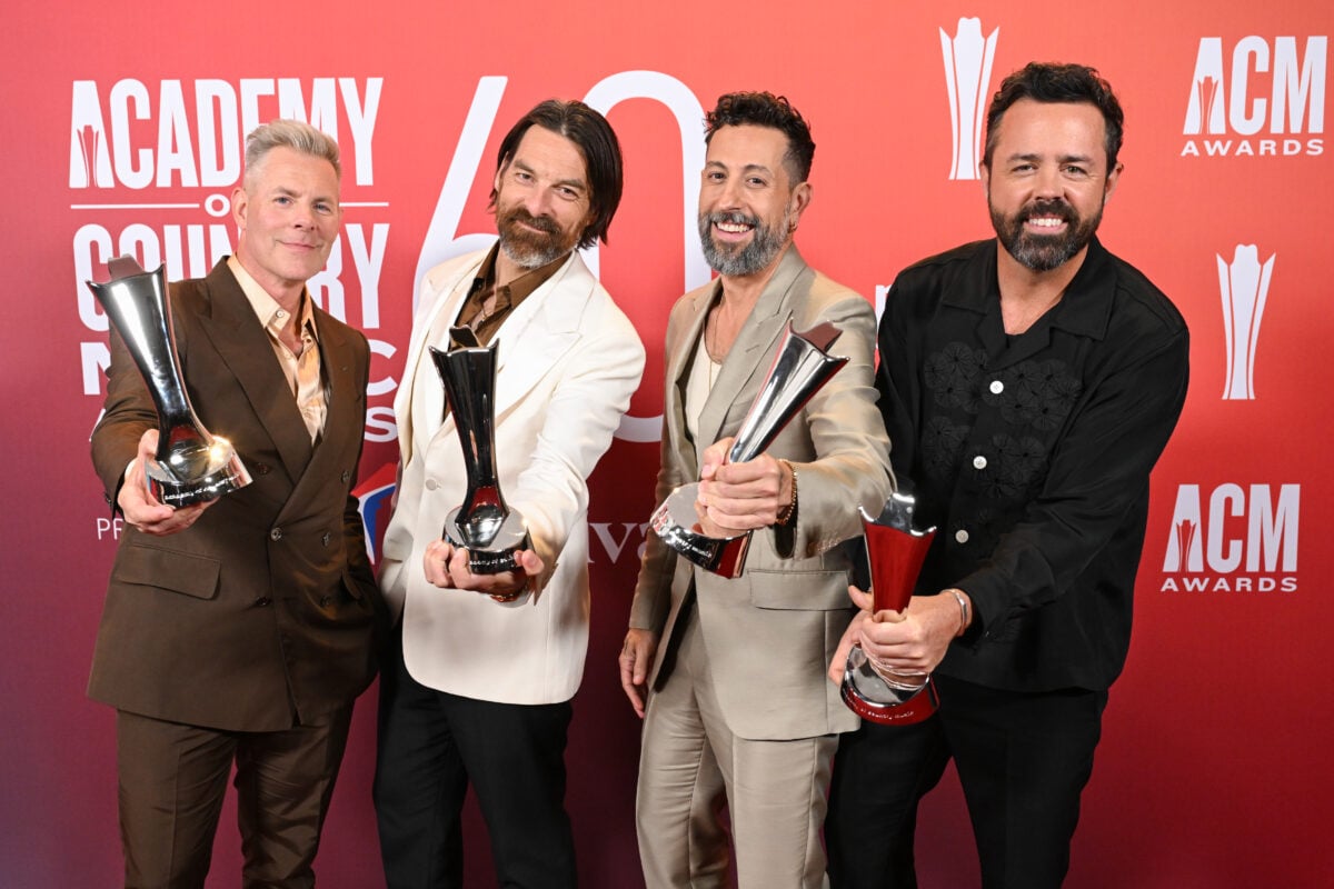 Old Dominion posing with the trophies on red carpet at 2025 ACM Awards