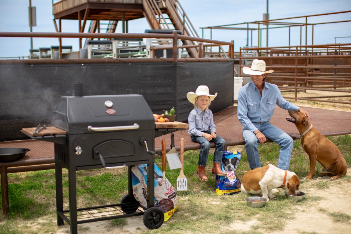 J.B. Mauney with his son, Jagger, his dogs Larry and Tono, grilling