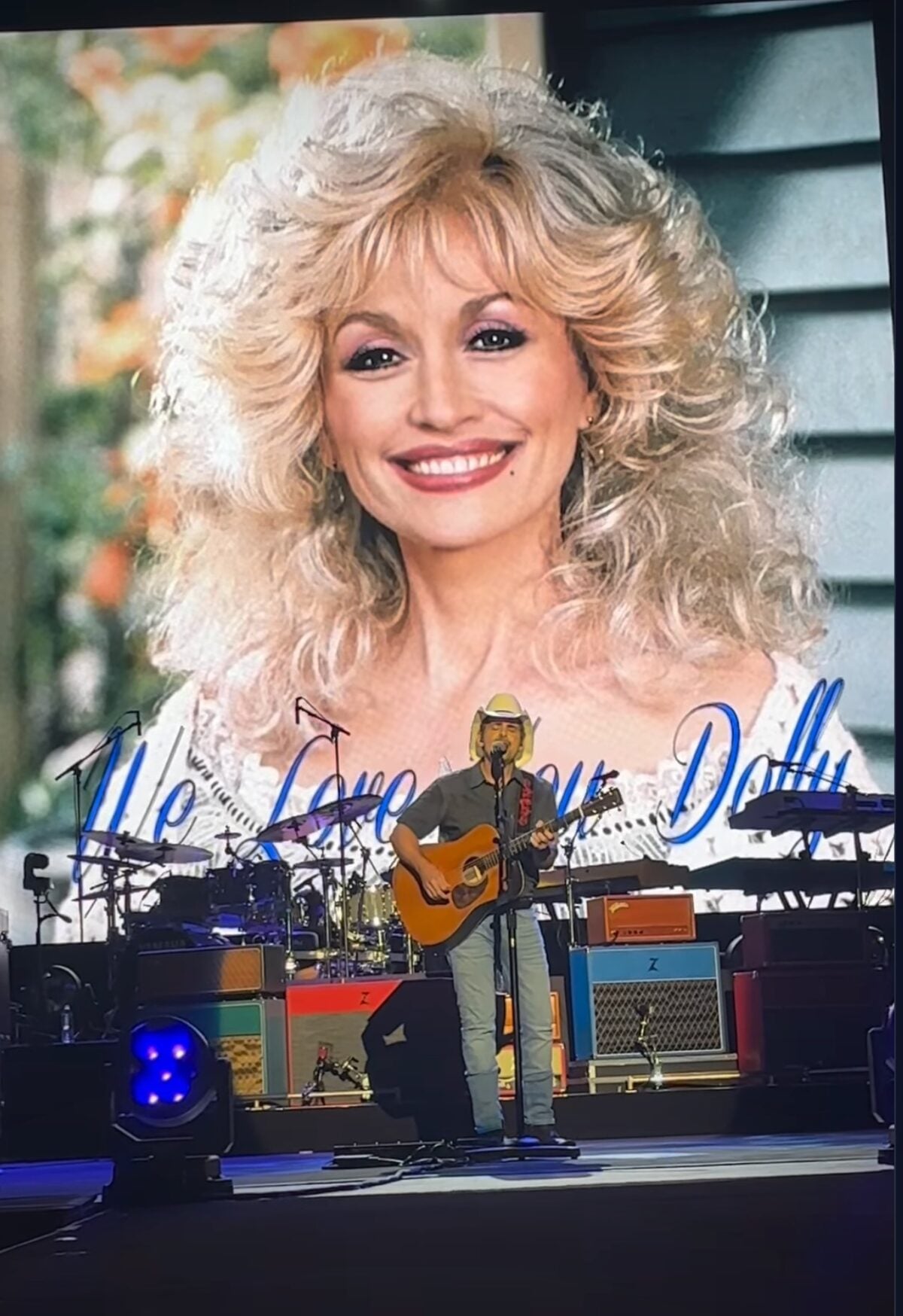 "We love you, Dolly" on the screen behind Brad Paisley