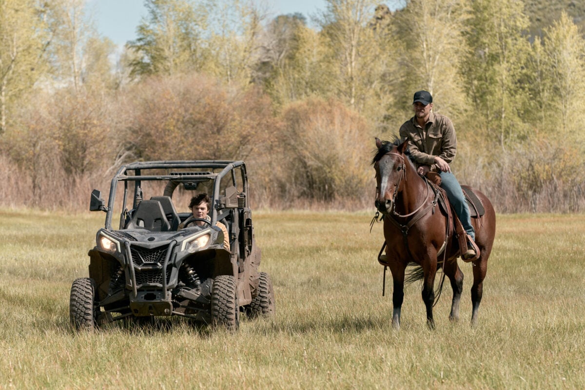 Luke Grimes as Kayce Dutton in Season 2 of the Yellowstone spin-off Marshals with his son Tate Dutton, played by actor Brecken Merrill