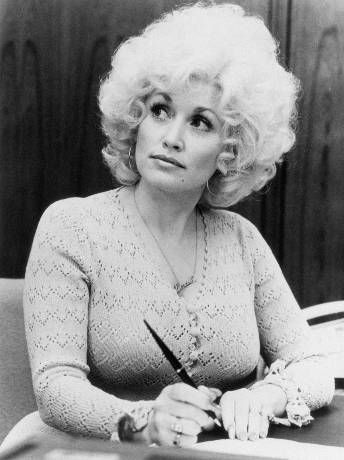 Dolly Parton taking a written note at the desk in a scene from "9 to 5"